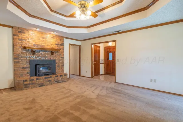 an empty room with a ceiling fan and a fireplace