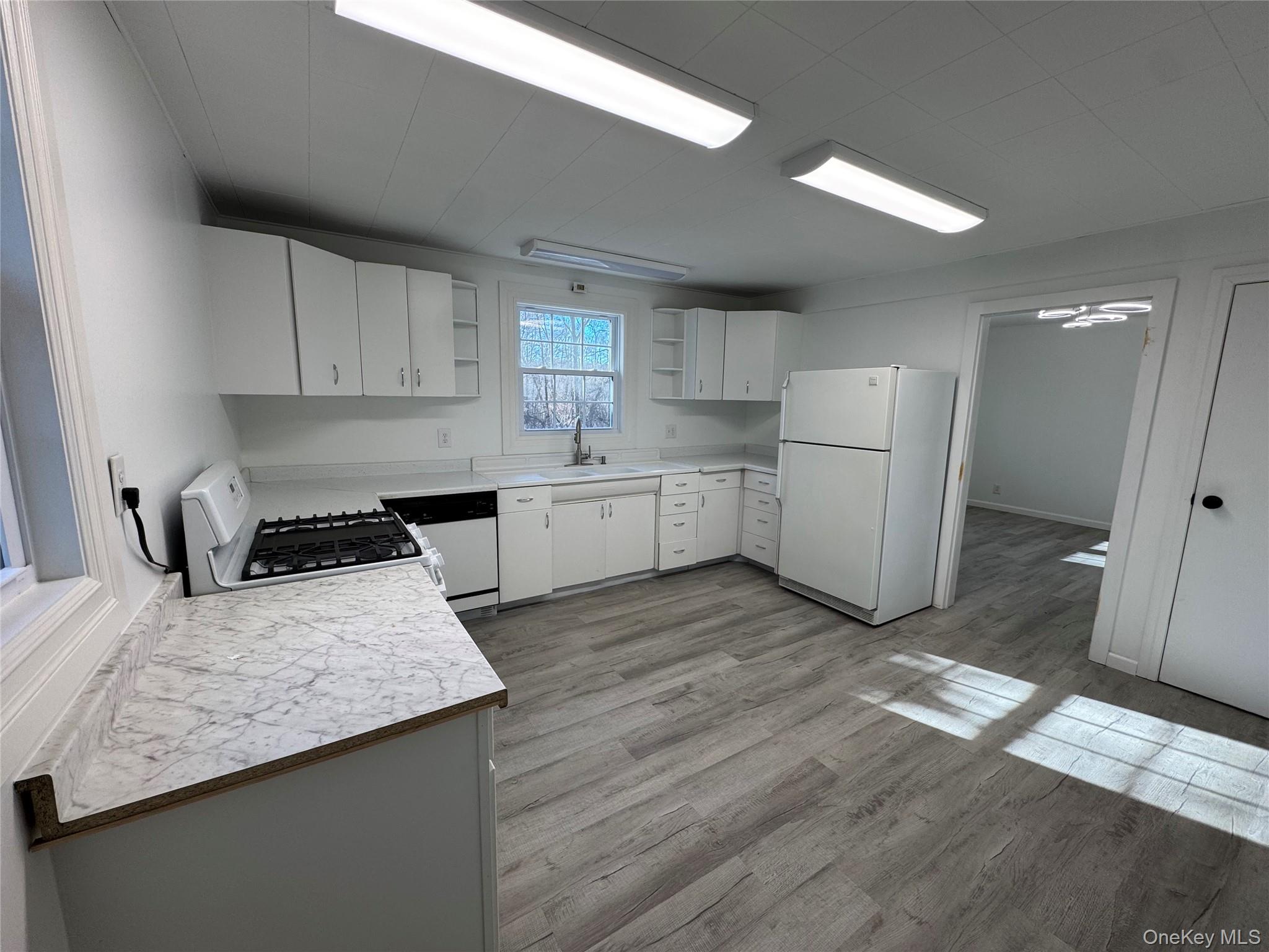 68 Chapel Road Newburgh, NY 12550 - Photo 13 of 17 a kitchen with a sink a stove a refrigerator and white cabinets
