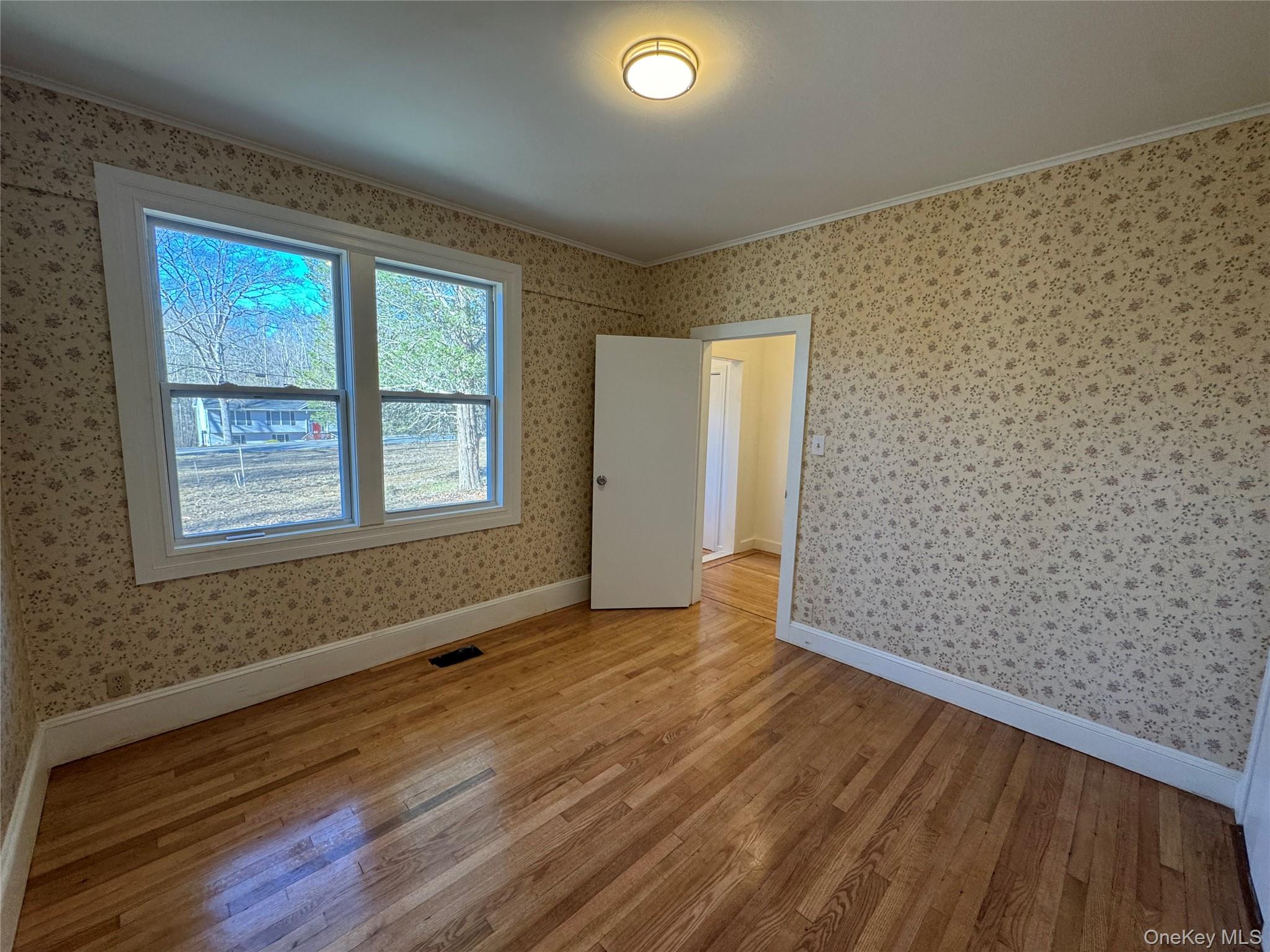 68 Chapel Road Newburgh, NY 12550 - Photo 4 of 17 a view of an empty room with wooden floor and a window