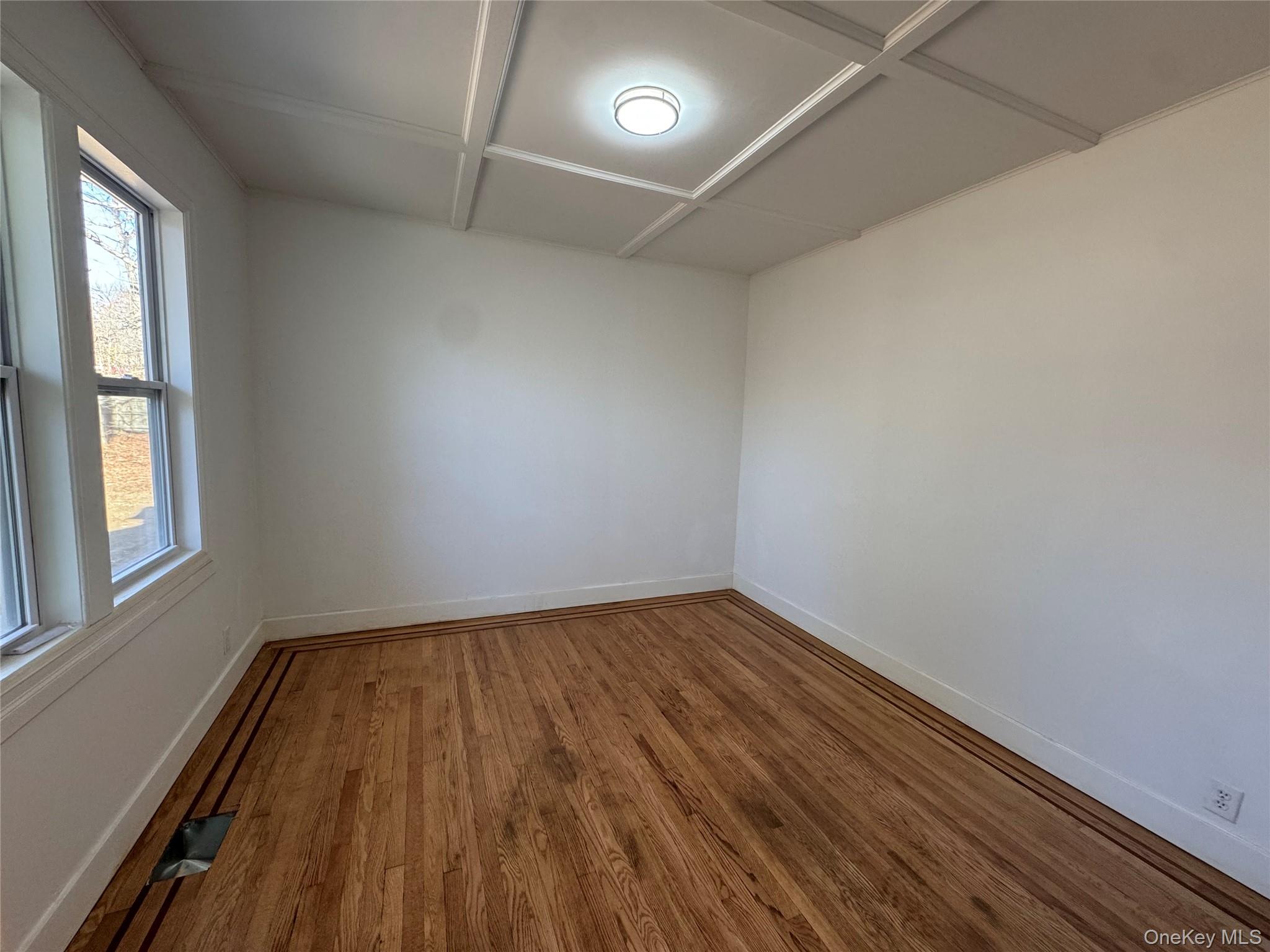 68 Chapel Road Newburgh, NY 12550 - Photo 5 of 17 an empty room with wooden floor and windows