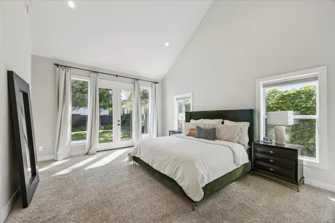 a bedroom with a bed and a large window