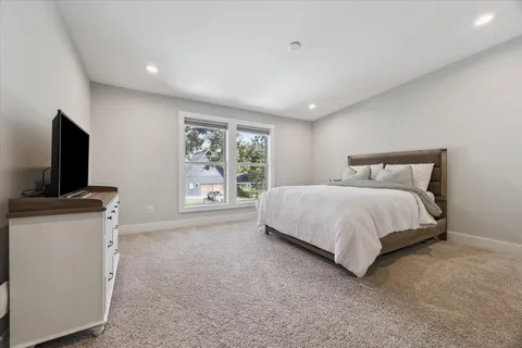 a bedroom with a large bed and a flat screen tv