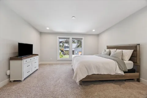 a spacious bedroom with a bed and a flat screen television