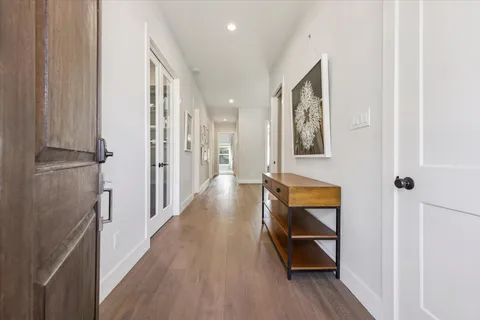 a hallway with wooden floor and cabinet