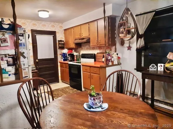 a kitchen with stainless steel appliances granite countertop a dining table chairs and a kitchen view