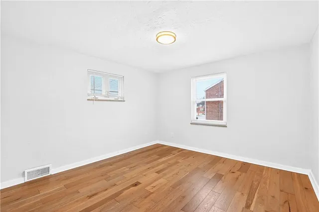 a view of a room with wooden floor and white walls