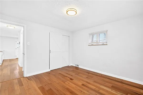 a view of a room with wooden floor and window