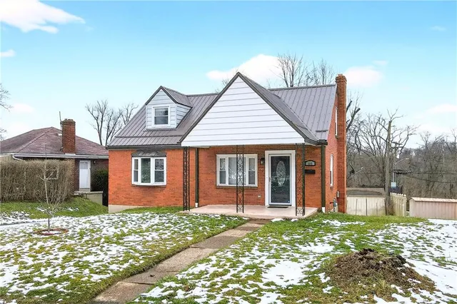 a view of a brick house with large windows and a yard