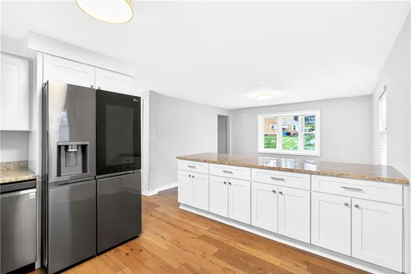 a kitchen with granite countertop a refrigerator and a sink