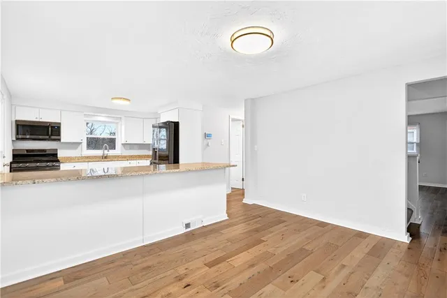 a view of a kitchen with wooden floor and a sink