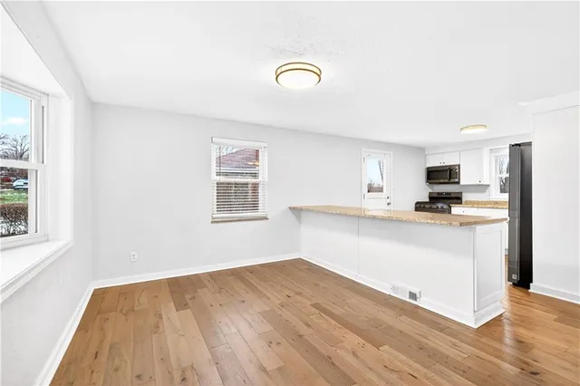 a view of kitchen with wooden floor and electronic appliances