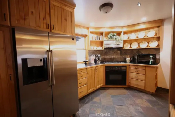a kitchen with stainless steel appliances granite countertop a refrigerator and a sink