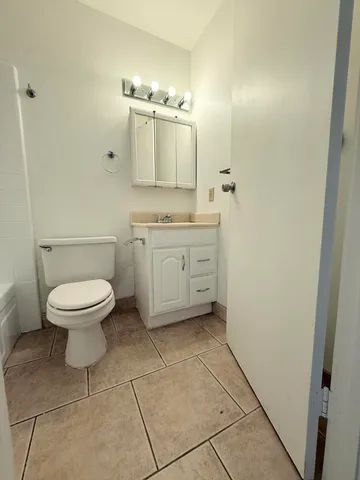 a spacious bathroom with a toilet sink and mirror