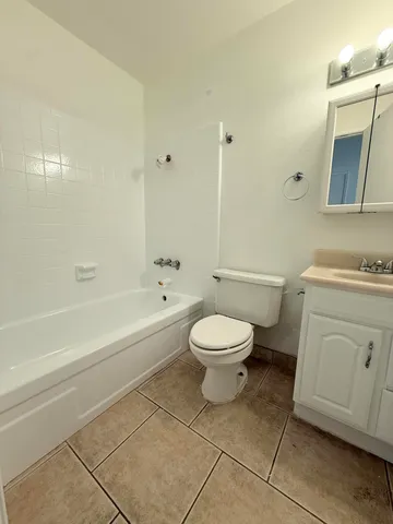 a bathroom with a toilet a sink a mirror and vanity
