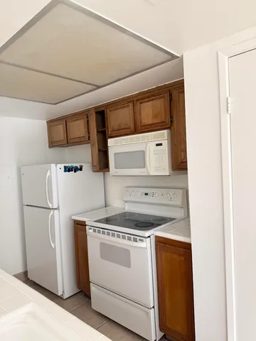 a kitchen with a stove top oven and refrigerator