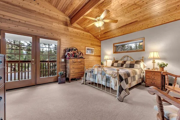 a bedroom with a bed next to a large window with the view of balcony