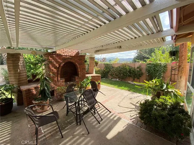 a patio with a table and chairs and potted plants