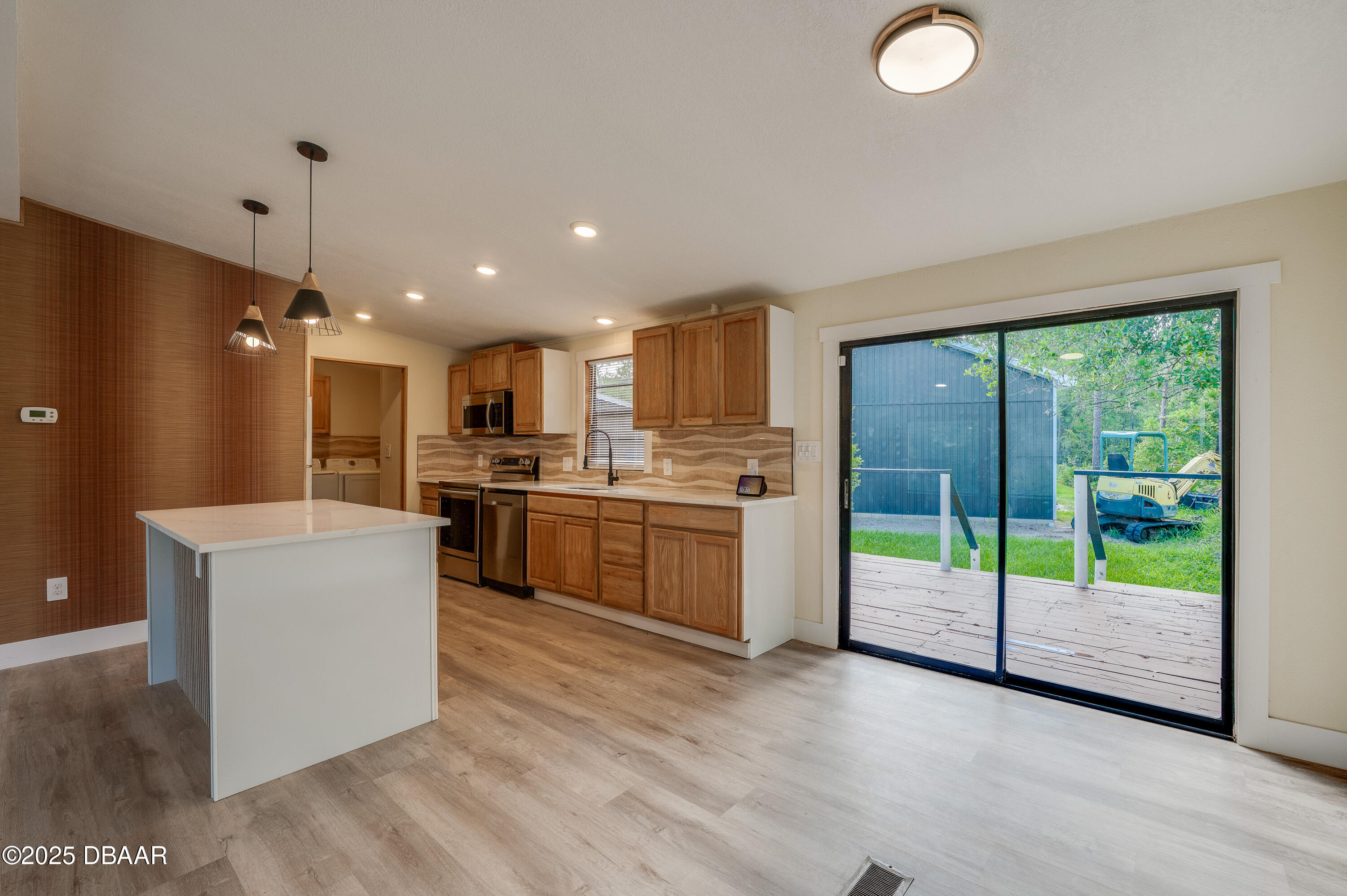 3669 General Marshall Road Daytona Beach, FL 32124 - Photo 12 of 32 a kitchen with a refrigerator a sink dishwasher with a stove and white cabinets