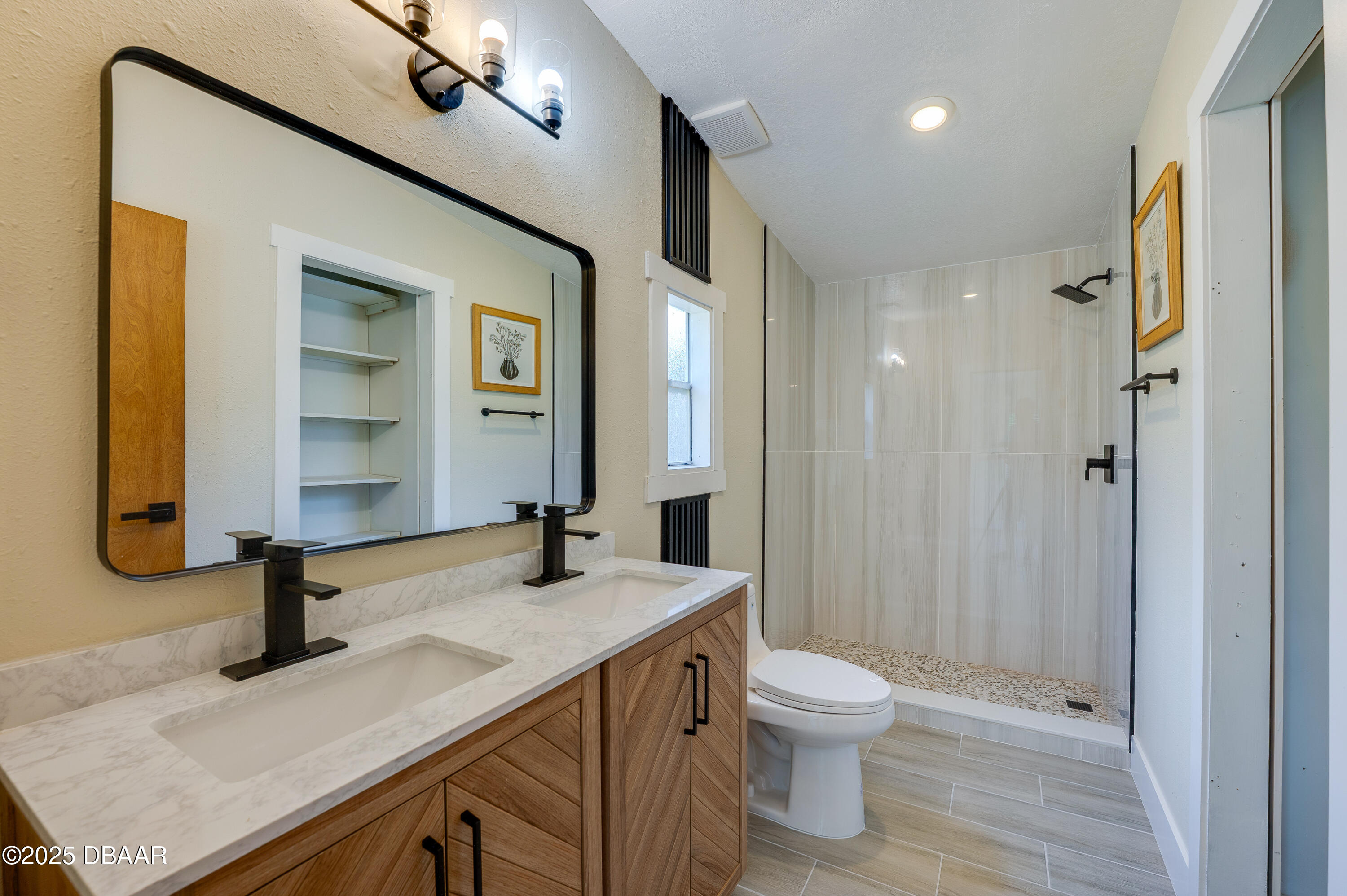 3669 General Marshall Road Daytona Beach, FL 32124 - Photo 19 of 32 a bathroom with a sink a toilet and a large mirror
