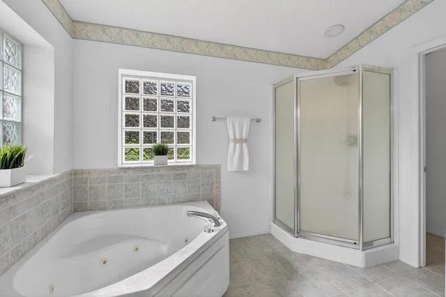 a bathroom with a tub shower and window
