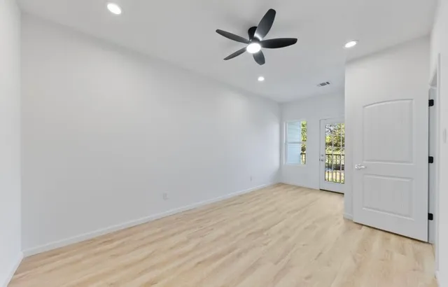 an empty room with closet and a ceiling fan