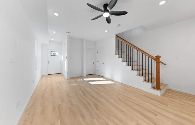 a view of empty room with wooden floor and window
