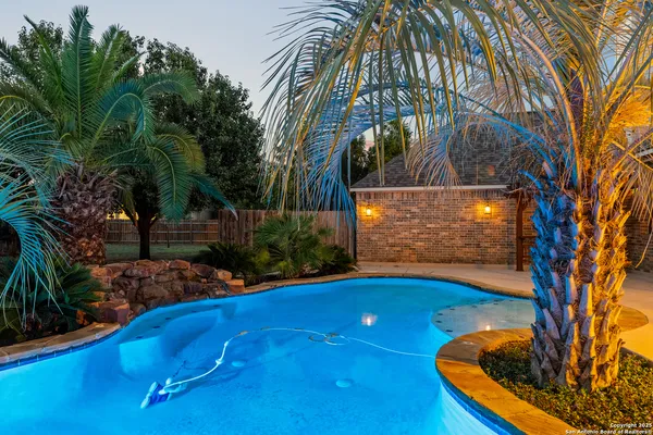 a view of swimming pool with a backyard and trees