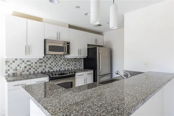 a kitchen with stainless steel appliances granite countertop a sink stove and refrigerator