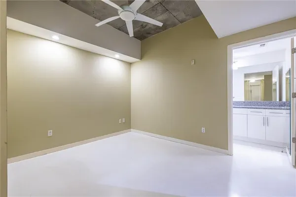 an empty room with a ceiling fan and a window