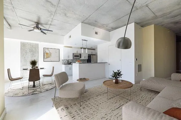 a living room with lots of furniture and view of kitchen