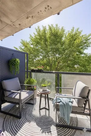 a balcony with wooden floor and outdoor seating