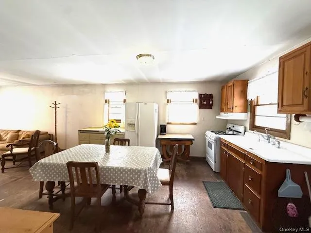 a kitchen with a dining table chairs and white appliances