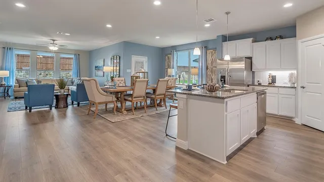 a kitchen with granite countertop white cabinets and stainless steel appliances