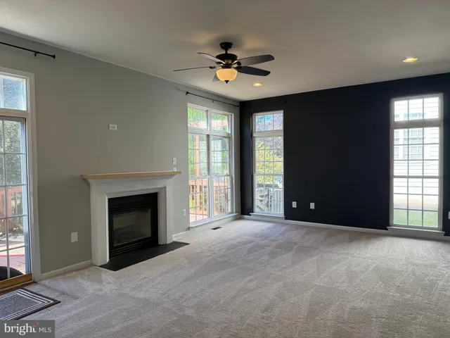 a view of an empty room with a fireplace and a window