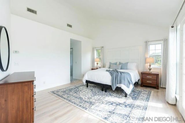 a spacious bedroom with a bed and glass window