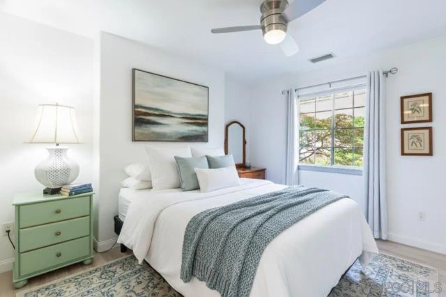 a bedroom with a bed and a painting on the wall