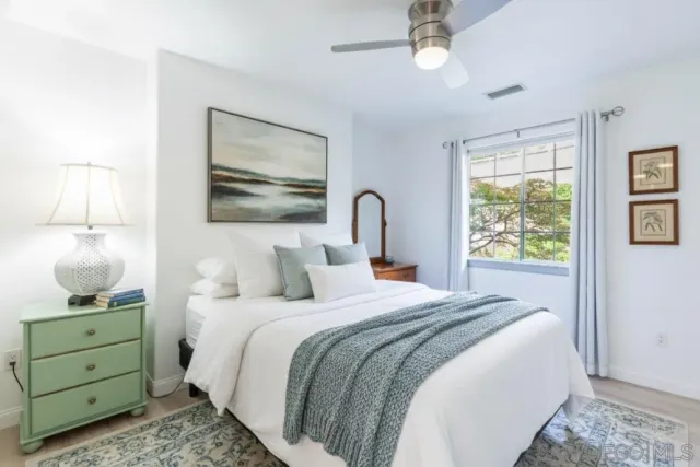 a bedroom with a bed and a painting on the wall