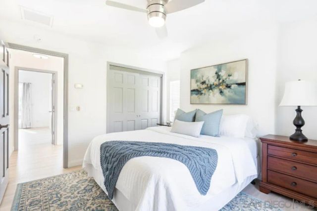 a bedroom with a bed a window and a potted plant