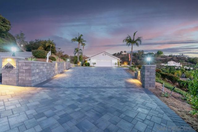 a view of a house with a yard and potted plants