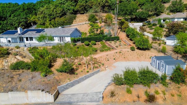 a front view of a house with a yard and mountain view in back