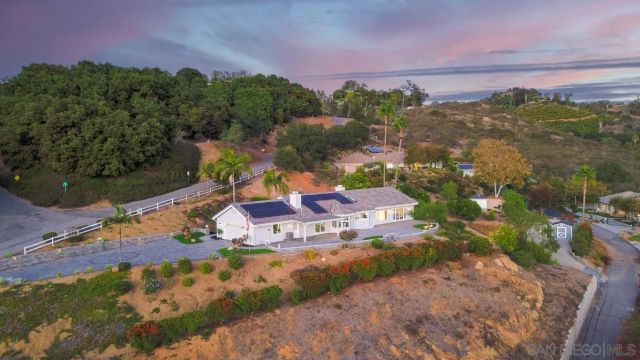 an aerial view of residential houses with outdoor space and trees