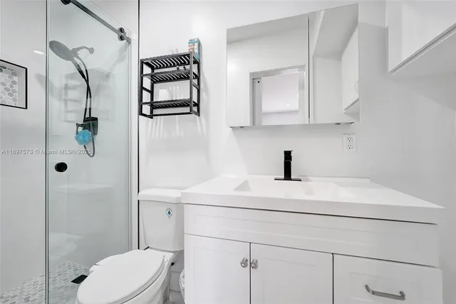 a bathroom with a sink a toilet and shower