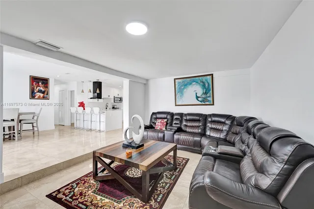 a kitchen with stainless steel appliances kitchen island sink refrigerator and microwave