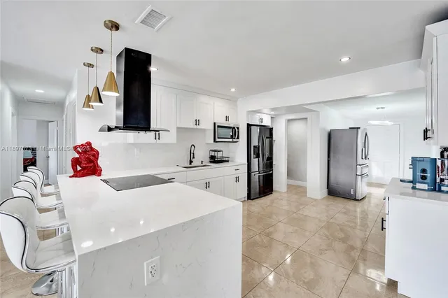 a kitchen with stainless steel appliances a refrigerator sink and microwave