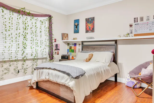 a bedroom with a bed and a window with chair