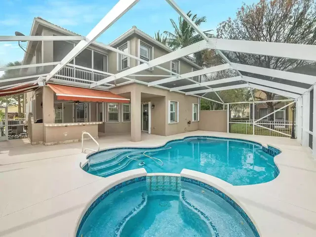 a view of a white house with a swimming pool and sitting area