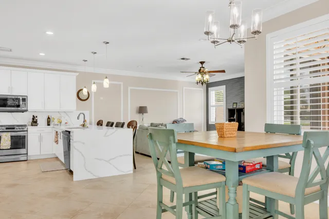 a kitchen with a dining table chairs stainless steel appliances and cabinets