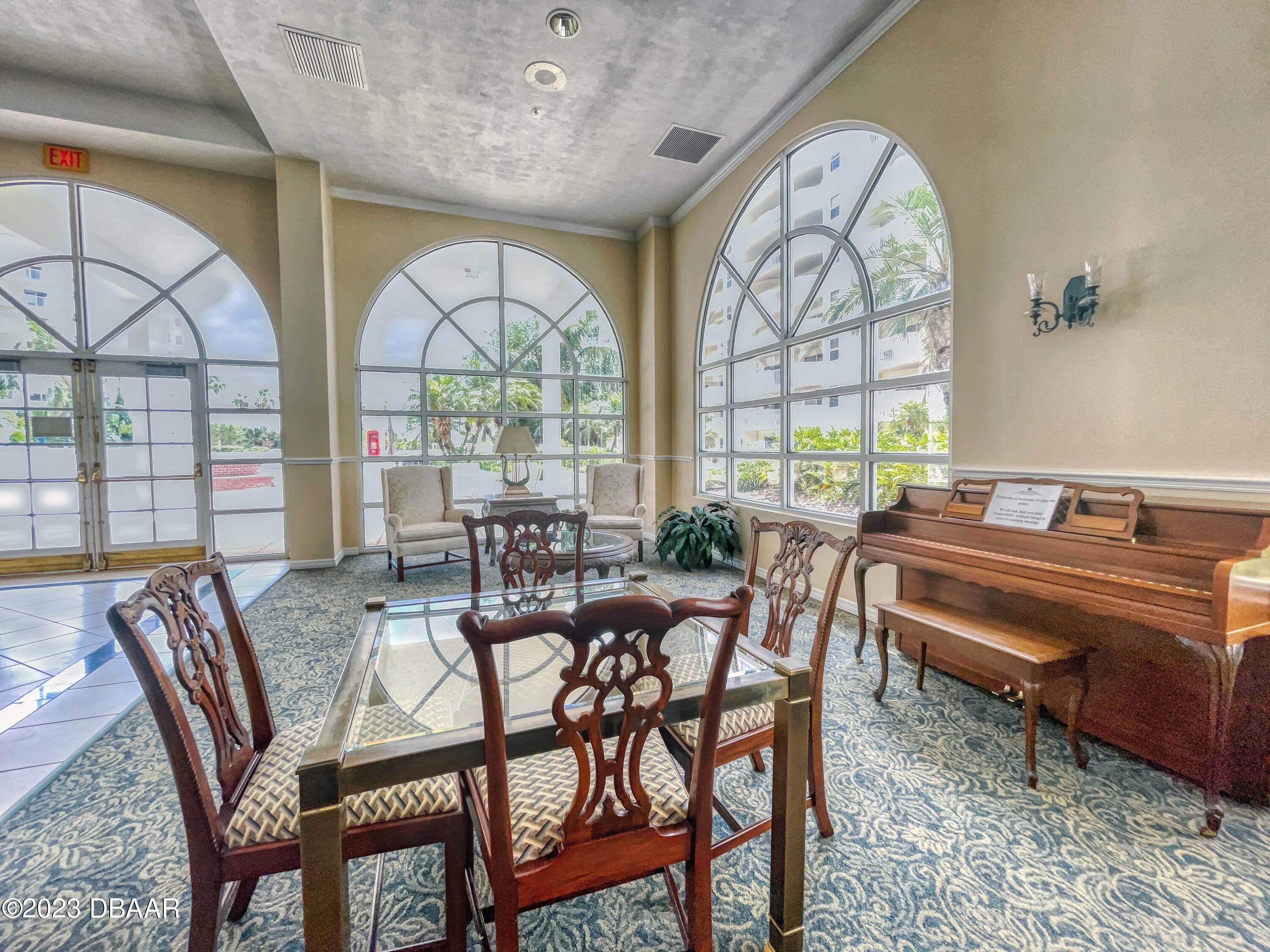1 John Anderson Drive, Unit PH7 Ormond Beach, FL 32176 - Photo 113 of 134 a view of a dining room with furniture a chandelier and wooden floor
