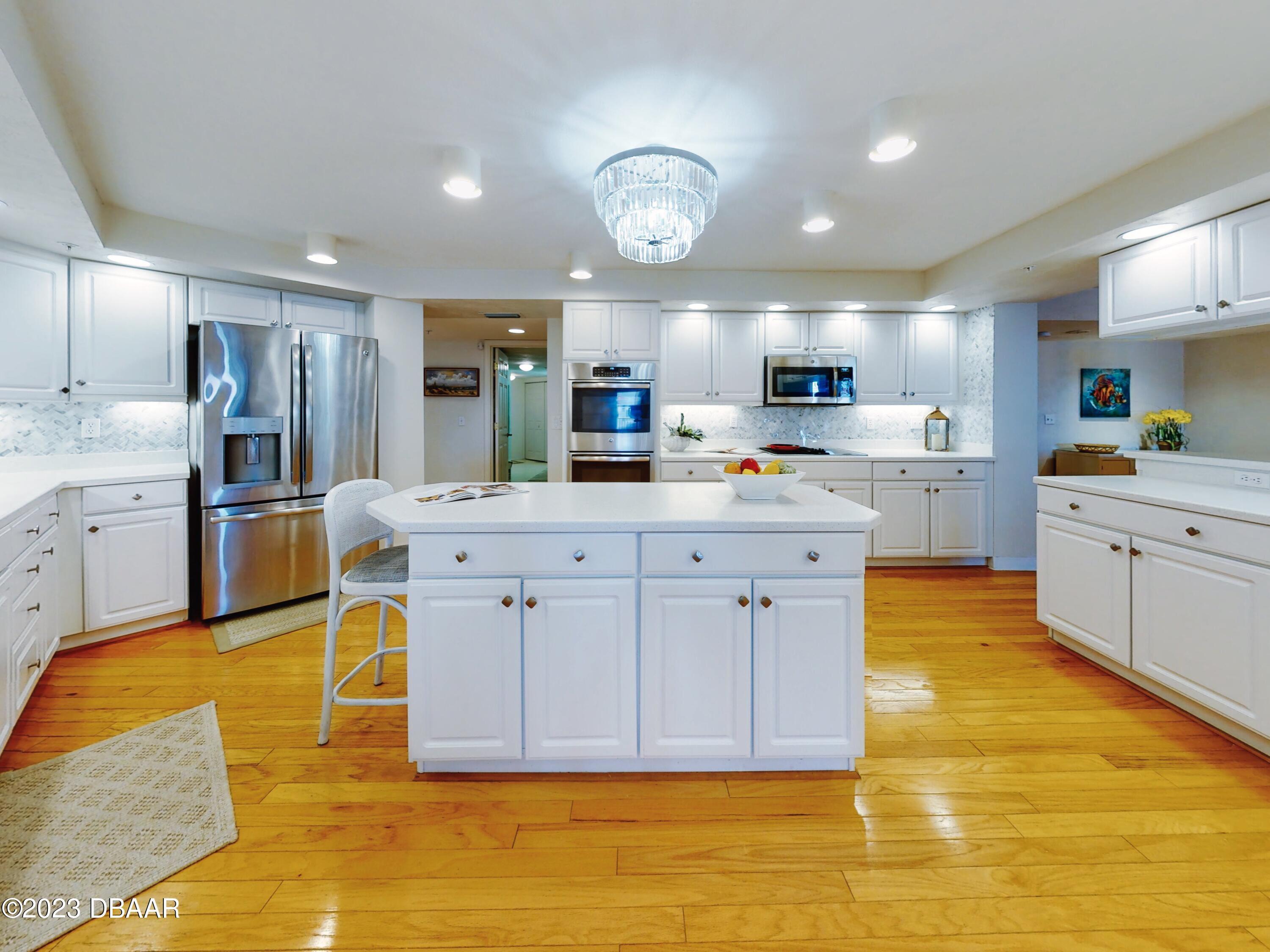 1 John Anderson Drive, Unit PH7 Ormond Beach, FL 32176 - Photo 54 of 134 a kitchen with stainless steel appliances granite countertop a sink a stove a refrigerator cabinets and chairs