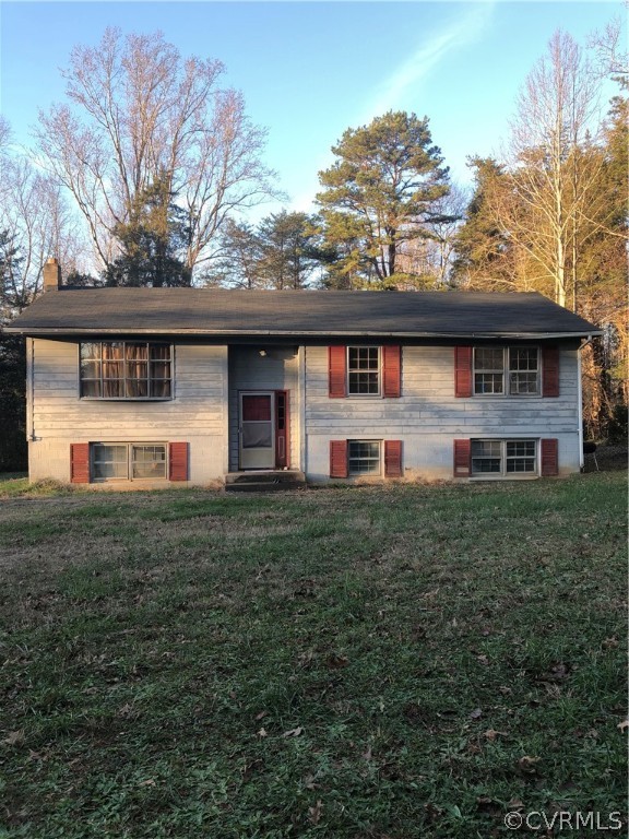 a front view of house with yard and trees in the background